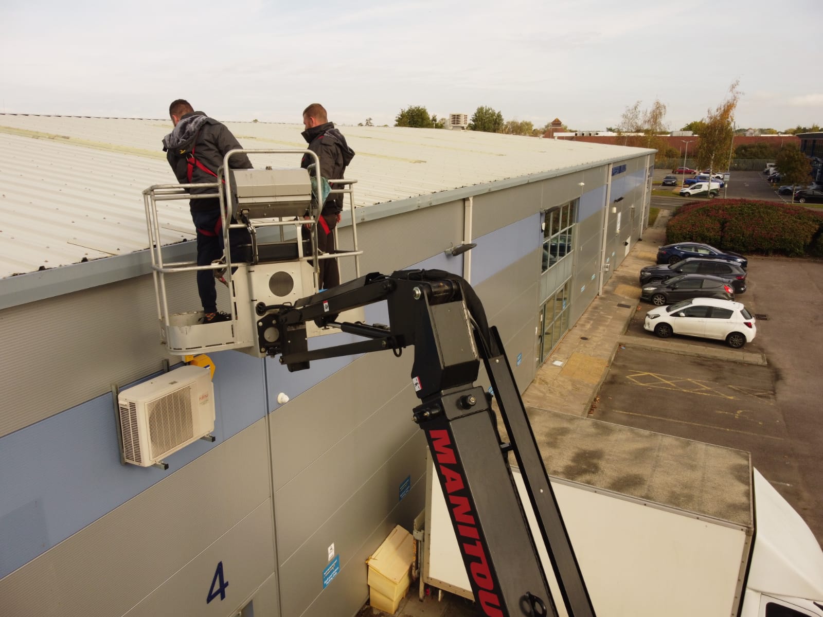 Expert team performing high-level gutter clearance on multi-storey building